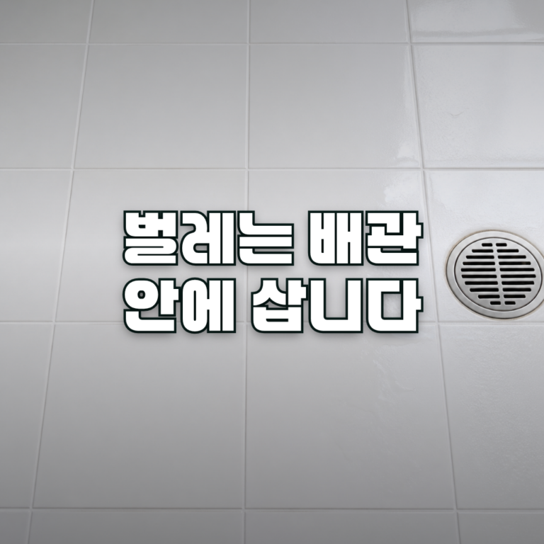 A close-up of a clean white tiled bathroom floor with a stainless steel round floor drain slightly off to one side, soft